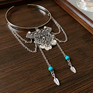 Close-up detail of a silver bohemian armband with tassel chains and turquoise beads