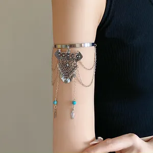 Vintage bohemian silver arm cuff with diamond tassel pendant worn on upper arm for women