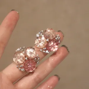 Gros plan détaillé de boucles d'oreilles fleurs roses sculptées sur base en argent