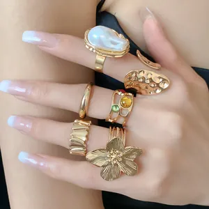 Detalle macro de un conjunto de elegantes anillos dorados vintage con flores y perlas