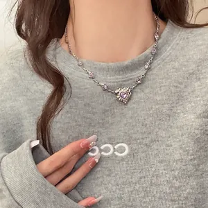 Detailaufnahme einer silbernen Vintage-Halskette mit lila herzförmigen Zirkonia-Steinen