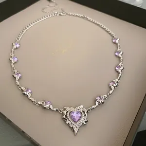 Detailansicht einer silberfarbenen Halskette mit lila herzförmigem Stein und Zirkonia