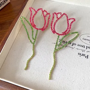 Statement hollow tulip drop earrings featuring vibrant pink and green rhinestones