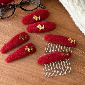 Red flocked hair clips and combs with golden horse charms displayed on a wooden surface