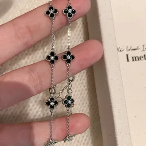 Detail of silver-tone adjustable bracelet with zircon-centered black flower motifs
