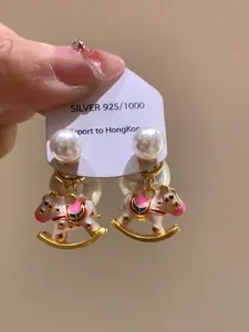 Detailed view of enamel rocking horse earrings with pearls and S925 silver stamp