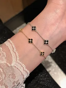 Close-up macro view of gold and silver plated flower bracelets with black zircon clovers