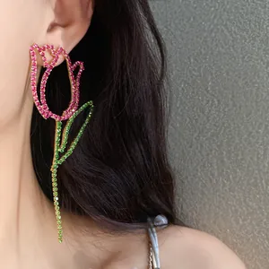 Close-up of statement hollow tulip earrings featuring pink and green rhinestones