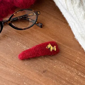 Close-up of elegant red flocked BB hair clip featuring a small golden horse charm