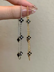 Close-up of gold and silver plated clover bracelets with sparkling zircon accents