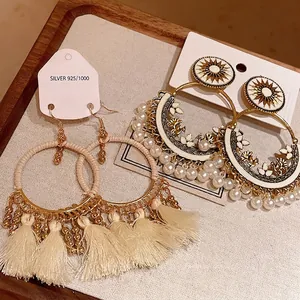 Elegant Bohemian ethnic style hoop earrings with cream tassels and pearl accents on display