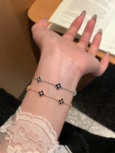 Close-up of elegant adjustable bracelets with black clover motifs and zircon stones