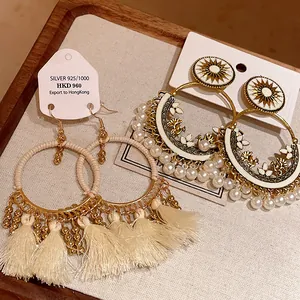 Elegant bohemian style round tassel and sun-patterned pearl earrings on display.