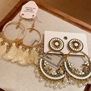 Close-up detail of ethnic bohemian hoop earrings with tassels and pearl-like accents