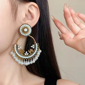 Close-up detail of bohemian ethnic round tassel earrings with pearl fringe and sunburst design