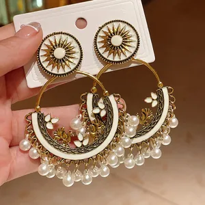 Bohemian ethnic round hoop earrings with sun motif and pearl tassel details