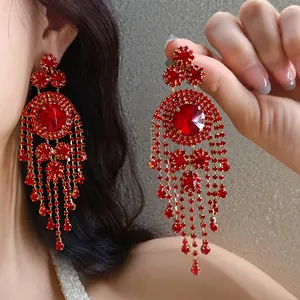 Exquisite Nahaufnahme von roten runden Quastenohrringen aus Strass im eleganten Palaststil