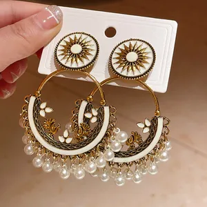 Macro view of bohemian round tassel earrings with sunburst motifs and pearl drops
