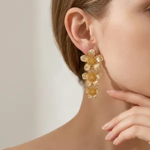 Pendientes colgantes de triple flor dorada con aguja de plata para orejas sensibles.