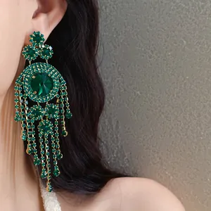 Nahaufnahme luxuriöser smaragdgrüner Strass-Ohrringe mit Quasten im Vintage-Palast-Stil