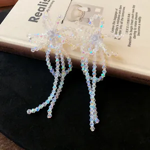 Dettaglio di eleganti orecchini a fiocco in perle di vetro con perno in argento