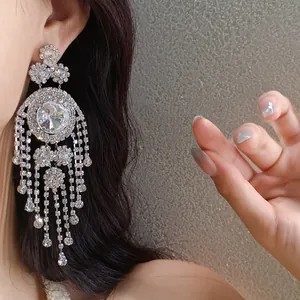 Detailaufnahme von silbernen Strass-Quasten-Ohrringen im Vintage-Palast-Stil mit Glanzeffekt.