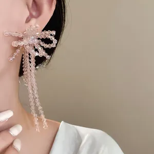 Primo piano di orecchini a fiocco in perle di vetro rosa indossati