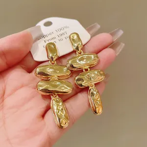 Primer plano de pendientes dorados con diseño de granos de metal con textura