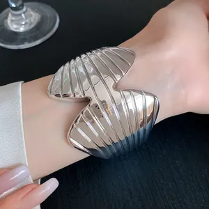 Close-up detail of a sculptural silver textured open cuff bracelet worn on the wrist