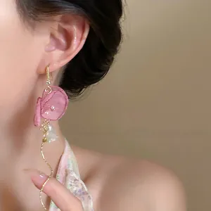 Gros plan d'élégantes boucles d'oreilles à pompon en tulle rose