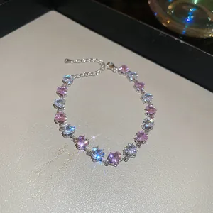 Detailansicht eines eleganten silbernen Herzarmbands mit rosa und weißen Zirkonsteinen.