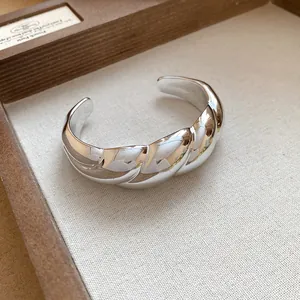 Macro view of the shiny silver twisted texture on the geometric open cuff bracelet