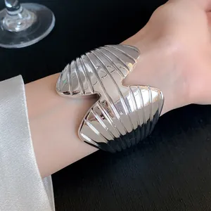 Detail shot of a silver textured acrylic cuff bracelet with a geometric open design
