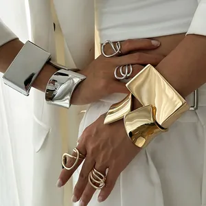 Fashionable wide asymmetrical metal bangles and geometric rings in gold and silver finish