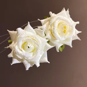 Dettaglio di orecchini a lobo a fiori in tessuto bianco con perline effetto rugiada