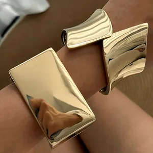 Detail shot of gold wide asymmetrical metal cuff bracelet featuring a shiny mirror finish