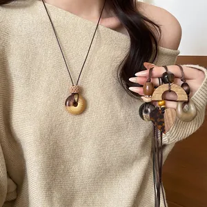 Macro view of retro wooden semi-circle and heart pendant necklaces on a model
