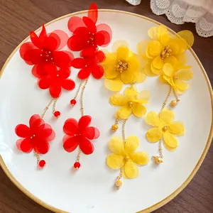 Detailed view of elegant handmade chiffon flower tassel earrings in vibrant red and yellow