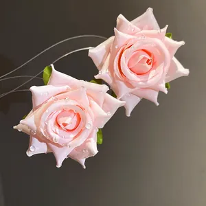 Macro di orecchini a rosa in tessuto rosa con delicate gocce di rugiada