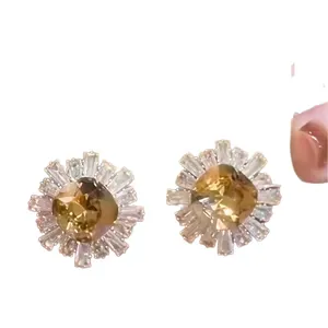 Sunburst champagne zircon stud earrings with gold finish and baguette crystal halo