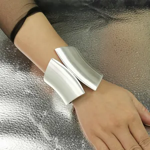 Close-up view of wide asymmetric silver cuff bracelet with brushed metal finish.