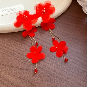 Detailed view of red chiffon flower tassel earrings with glass beads