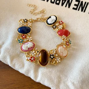 Close-up of vintage French-style gold bracelet with resin cameos and floral accents