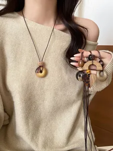 Detailed view of handmade vintage wooden and resin pendant necklaces on a model