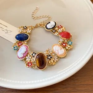 Elegant French vintage gold bracelet featuring colorful resin cameos and rhinestone flowers.