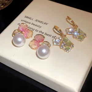 Detailed macro view of elegant rhinestone earrings with pearls and geometric crystals