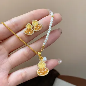 Close-up detail of gold-plated gourd jewelry set with yellow stones and small pearls