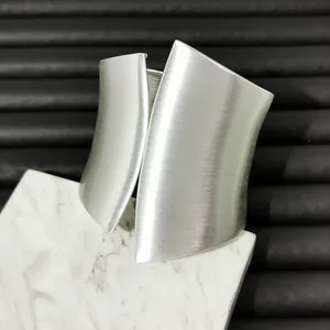 Close-up of wide asymmetric cuff bracelet with a matte brushed silver finish