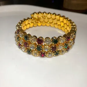 Visuale macro dettagliata di un bracciale vintage a tre file con cristalli colorati
