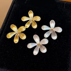 Elegantes pendientes de botón de flores de metal texturizado en acabados oro y plata